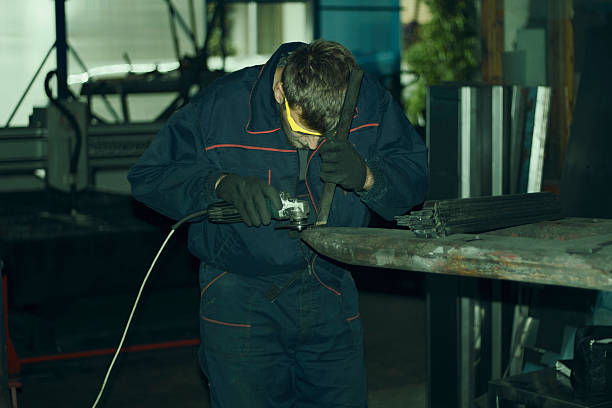 istock Manual worker grinding steel table in production hall. 619089484