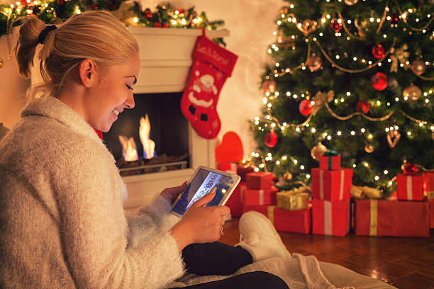 istock Young beautiful girl using digital tablet on Christmas night 619089722