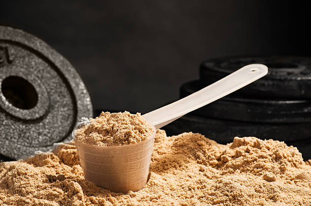 scoop di proteine del siero di latte su sfondo nero. difetti del cioccolato - whey protein concentrate foto e immagini stock