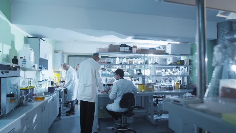 Timelapse footage of a team of scientists in white coats that are working in a modern laboratory.