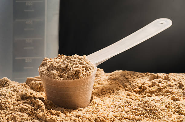 istock Scoop of whey protein on black background. Chocolate flawour 619228484