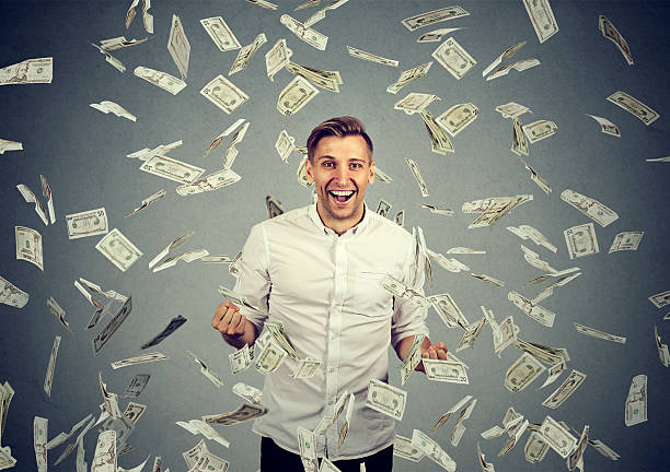 istock man celebrates success under money rain 619229198