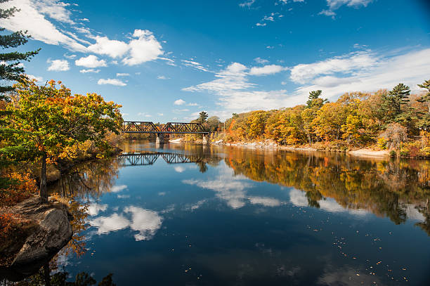 Railroad bridge over the Androscoggin River in Brunswick, Maine Railroad bridge over the Androscoggin River in Brunswick, Maine with fall foliage maine stock pictures, royalty-free photos & images