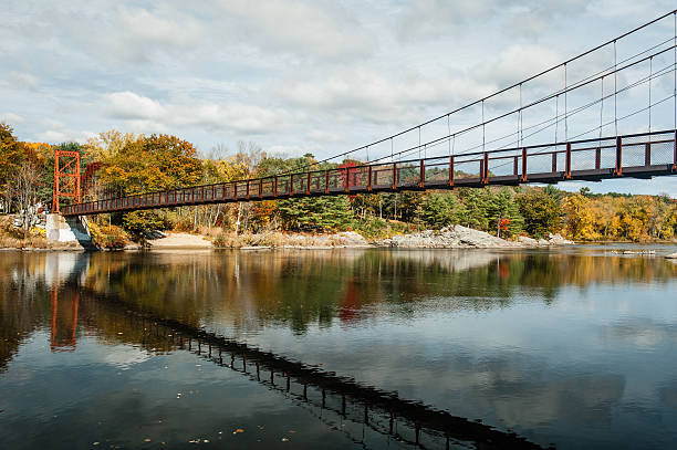 Swinging pedestrian bridge over the Androscoggin River in Brunswick, Maine stock photo