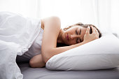Young beautiful Caucasian woman on bed having headache