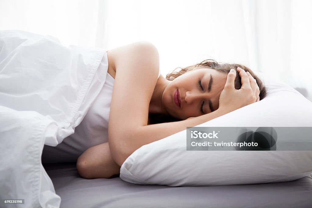 Young beautiful Caucasian woman on bed having headache Young beautiful Caucasian woman on bed having headache / insomnia / migraine / stress Sleeping Stock Photo