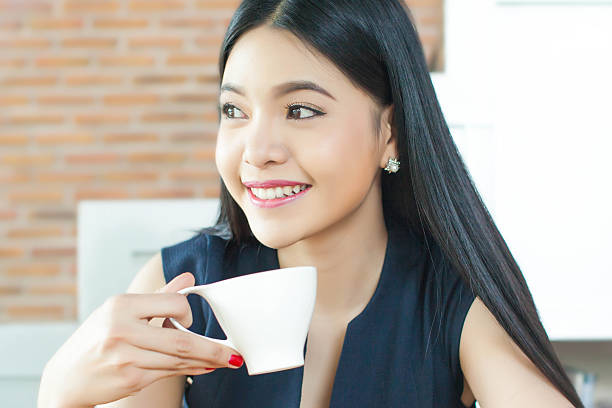 istock Asian Woman drinking coffee with smile on her face 619238784