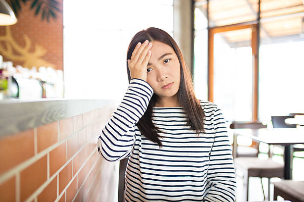 istock Woman has headache in the cafe 619239608