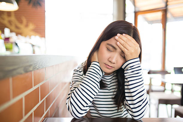 istock Woman has headache in the cafe 619239710