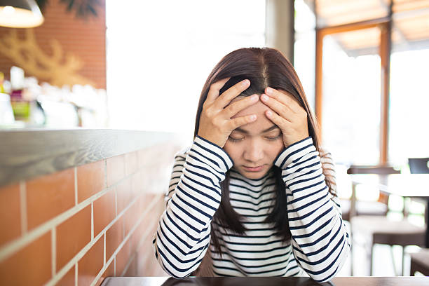 istock Woman has headache in the cafe 619239772