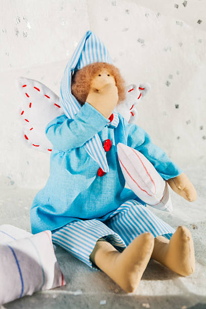 istock Soft textile doll in blue pajamas and a pillow 619245260