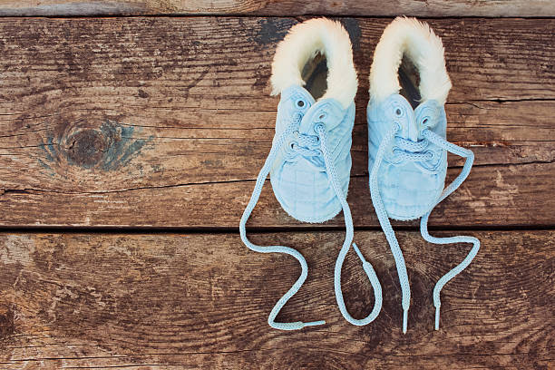 new year 2017 written laces of children's shoes 2017 new year written laces of children's shoes on old wooden background. Toned image. Top view.  baby new years eve new years day new year stock pictures, royalty-free photos & images