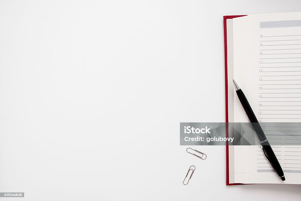 Blank notebook with pen and clips free space Blank notebook with pen and clips free space. Office supplies on empty white table, copy space for text or advertisement. Business, workplace, paperwork concept Meeting Stock Photo