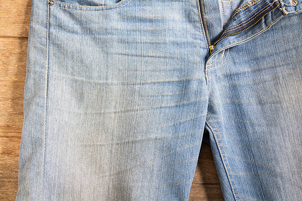 istock jeans stacked on a wooden background 619250812