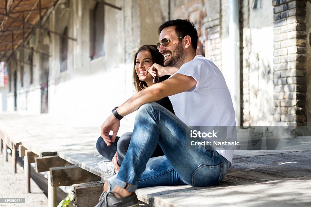 Portrait Of Young Couple Casual happy couple dating and sitting outdoor  Jeans Stock Photo