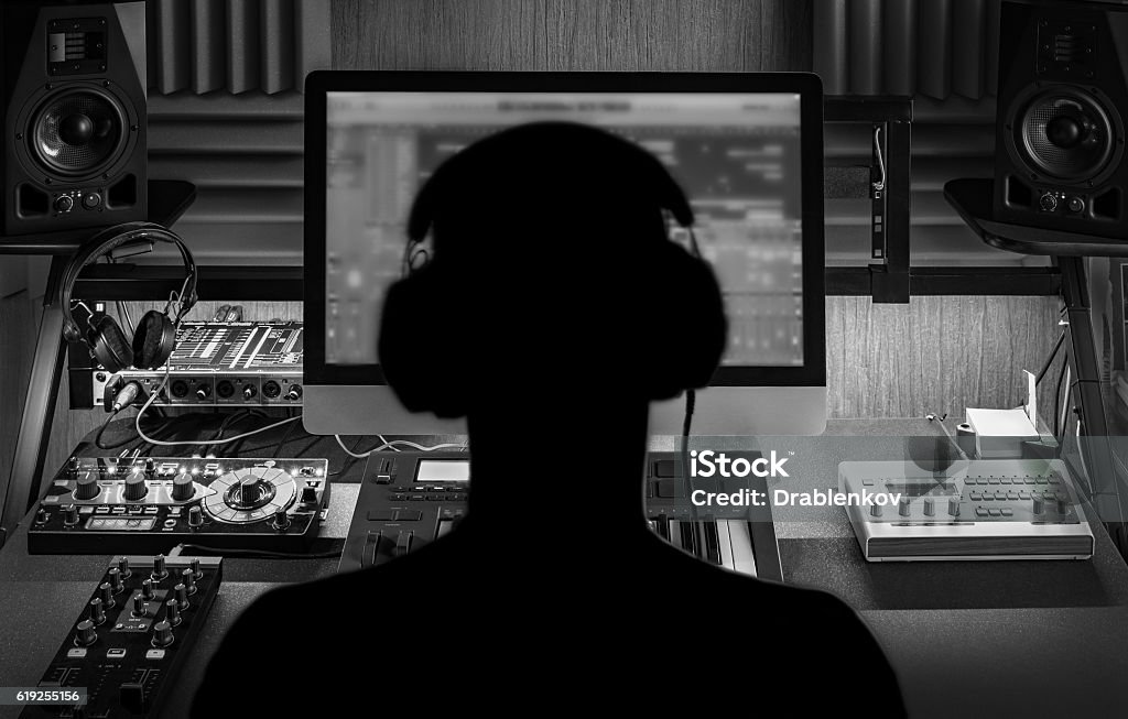 Man produce electronic music in studio Man produce electronic music in project home studio. Black and white monochrome image Music Stock Photo