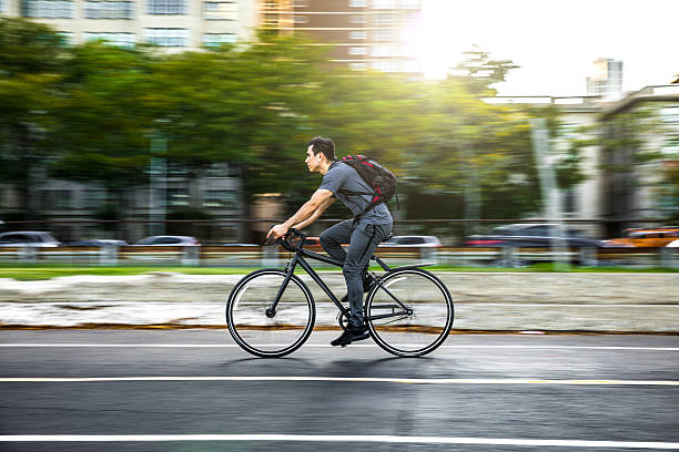 Young man cycling in the city, commuting to work Young man cycling in the city, commuting to work in Chicago - USA. chicago illinois photos stock pictures, royalty-free photos & images