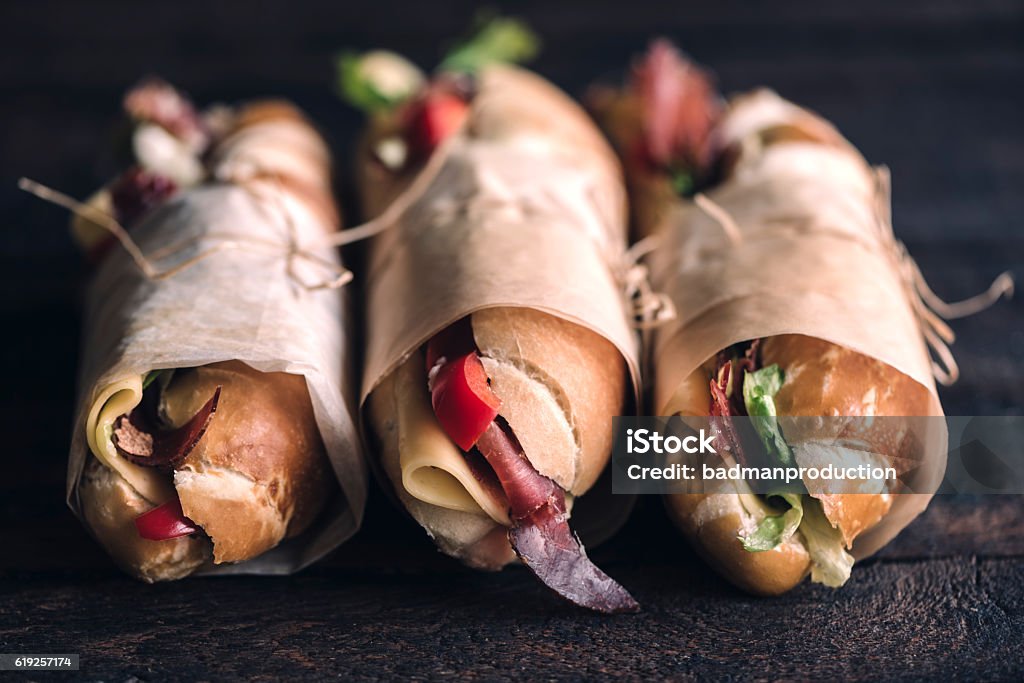 Three sumbmarine sandwiches Three submarine sandwiches on wooden background,selective focus Sandwich Stock Photo
