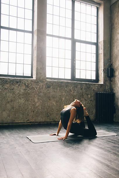 istock Young woman practicing yoga in urban loft: Cobra Pose (Bhujangasana) 619257326