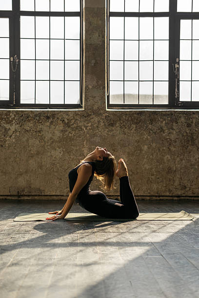 istock Young woman practicing yoga in urban loft: Cobra Pose (Bhujangasana) 619257436