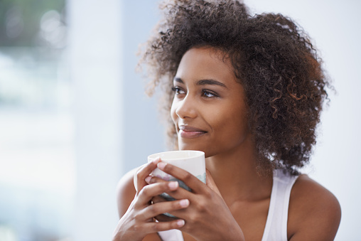 Shot of young woman enjoying a cup of coffee in the morning