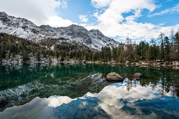 istock Autumn in mountain. Mountains and trees are reflected in a lake. 619258554