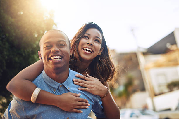 Falling in love is so much fun Shot of a happy young couple enjoying a piggyback ride outdoors heterosexual couple stock pictures, royalty-free photos & images