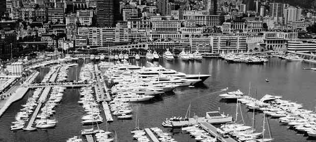Monte Carlo, Monaco - July 30, 2015: Rows of luxury motor yachts in Monaco marina all moored. This view is from the City wall beside the Palace and looking down on the harbour.
