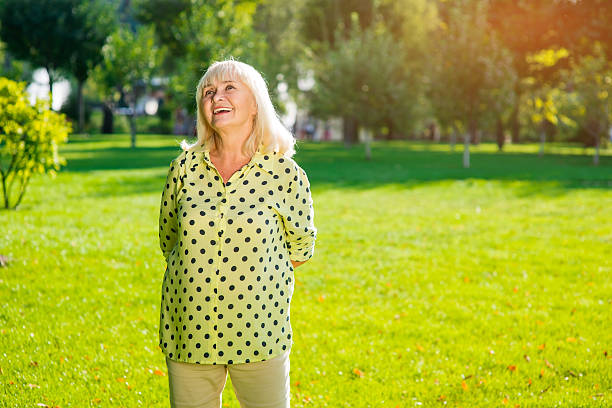 istock Senior woman standing and smiling. 619260642