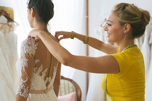 istock young bride being helped into her wedding dress 619261012