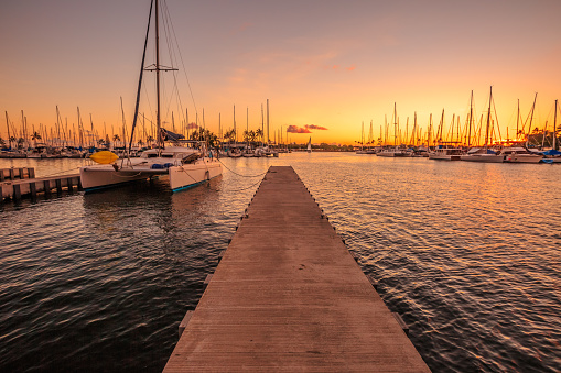 Wooden jetty in Ala Wai Harbor at twilight. Ala Wai Harbor is the largest small-boat and yacht harbor in Hawaii, situated between Waikiki and downtown Honolulu in Oahu Island, Hawaii, United States.