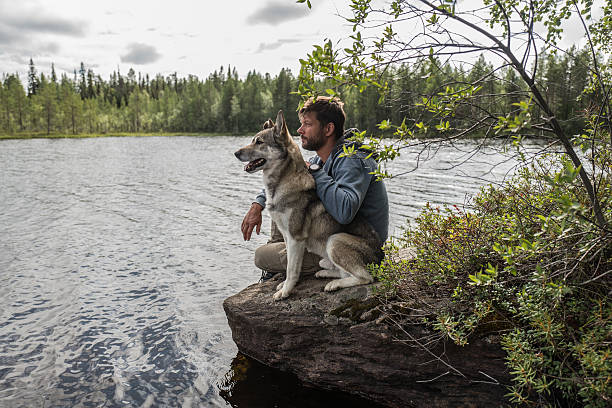 istock man and dog are sitting on the stone 619262918