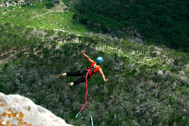 Jump rope. A man jumps from a cliff into the abyss. bungee jumping stock pictures, royalty-free photos & images