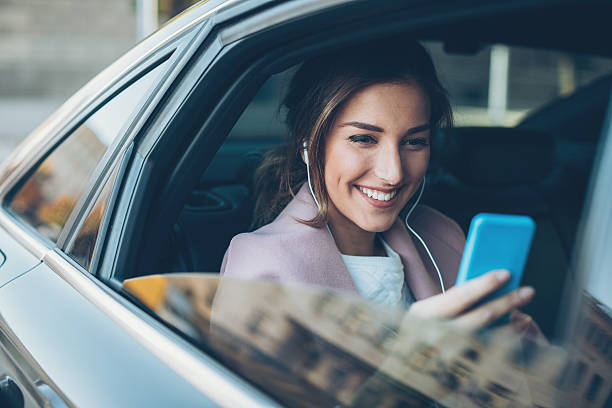 mujer con teléfono en el asiento trasero de un coche - city of nice audio fotografías e imágenes de stock