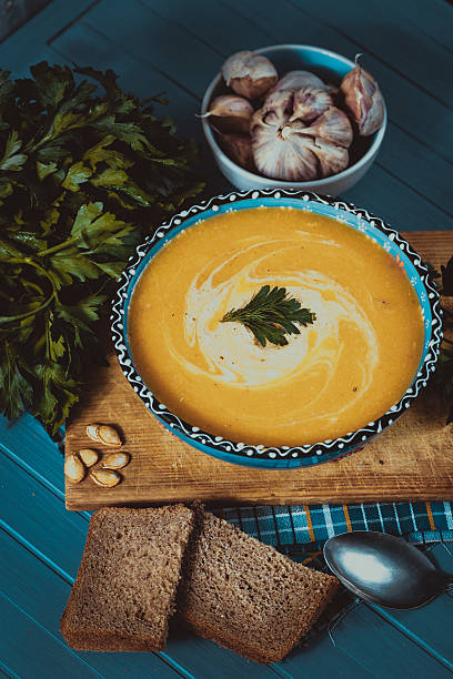 istock cream soup with pumpkin, greens, seeds and bread on blue 619267052