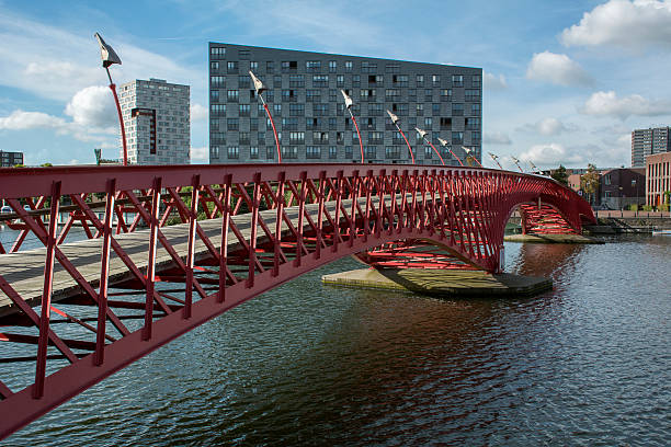 istock Red modern bridge in Amsterdam near several houses 619267192
