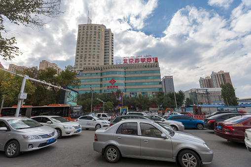 Urumqi, Xinjiang, China - October 4, 2016: Urumqi street view. Cars, Bus and Taxi on the road, business buildings on the road sides, incidental people on the background.