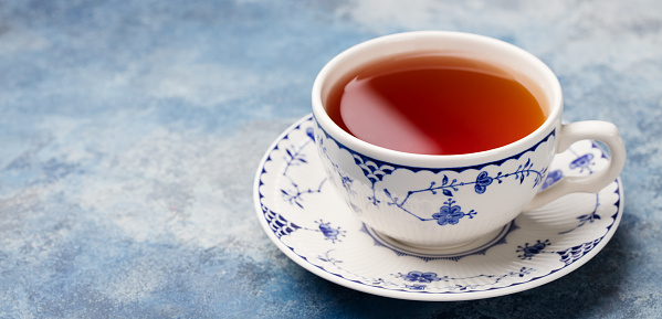 Cup of tea on a blue stone background. Copy space.