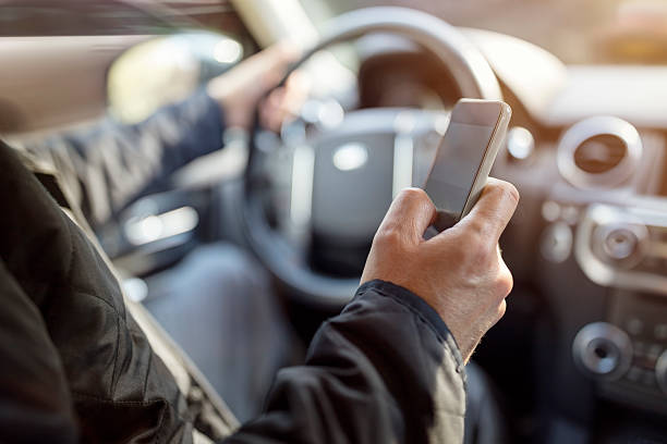 mensajes de texto mientras se conduce usando el teléfono celular en el automóvil - prohibido fotos fotografías e imágenes de stock