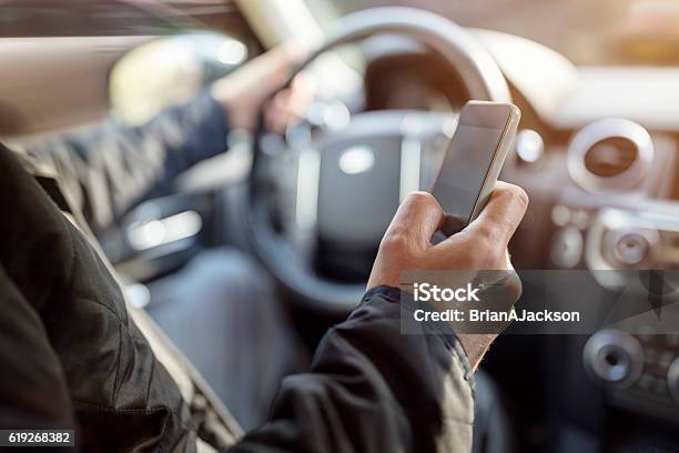 Texting While Driving Using Cell Phone In Car Stock Photo - Download Image Now - Driving, Distracted, Text Messaging
