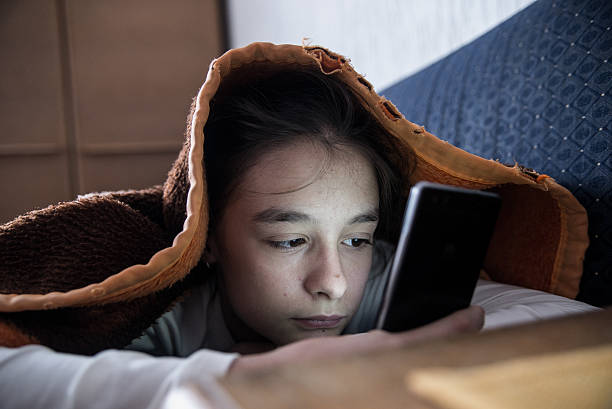 istock Female teen using phone in bed during the day 619268932