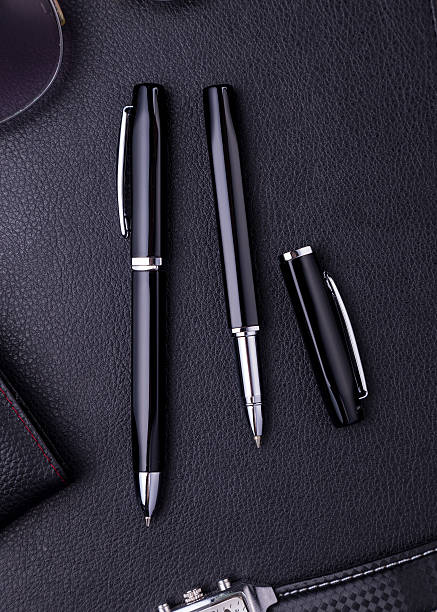 istock Pens lying on black leather background with copy space 619269518
