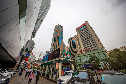 Urumqi, Xinjiang, China- October 13, 2016: Urumqi downtown street view. Bus and Taxi on the road, business buildings on the road sides, incidental people on the background.