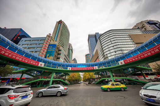 Urumqi, Xinjiang, China- October 13, 2016: Urumqi downtown street view. Bus and Taxi on the road, business buildings on the road sides, incidental people on the background.