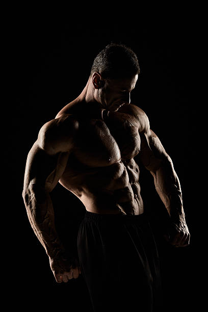 istock torso of attractive male body builder on black background. 619274284