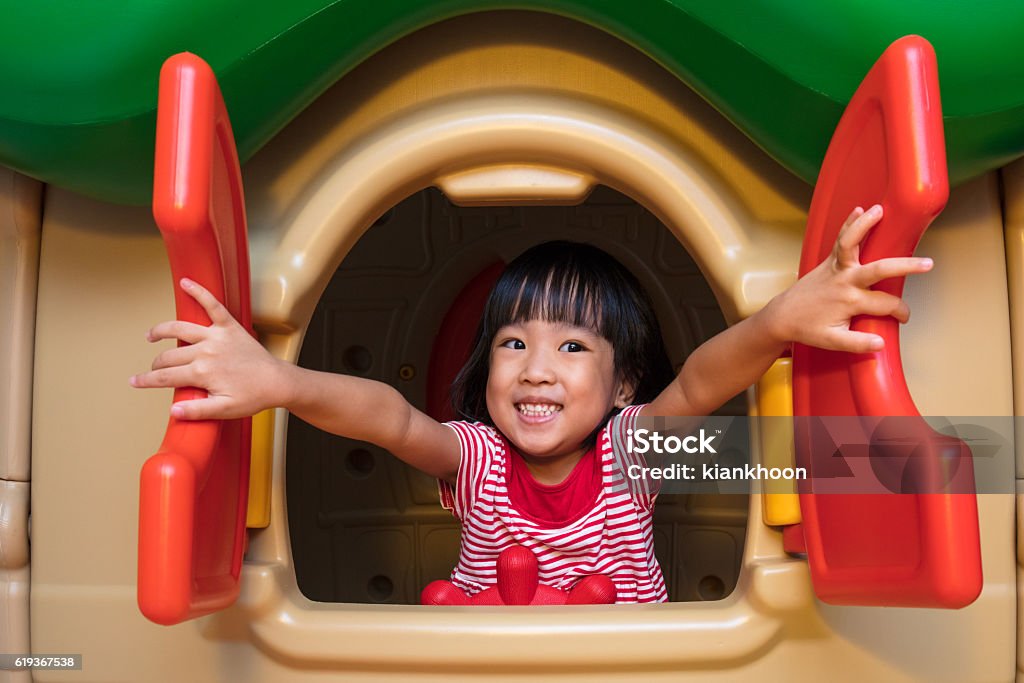 Asian Chinese little girl playing in toy house Asian Chinese little girl playing in toy house at indoor playground. Child Stock Photo