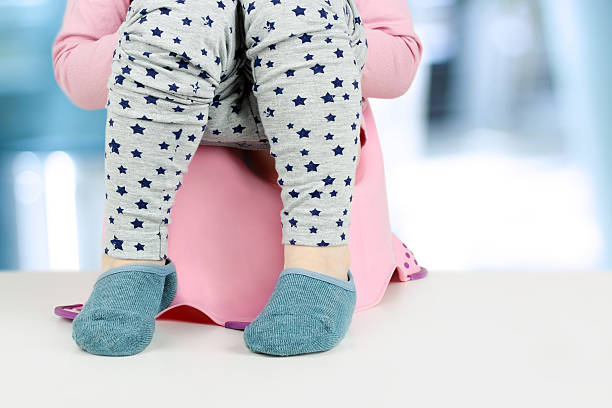 istock Children's legs hanging down from a chamber-pot 619369188