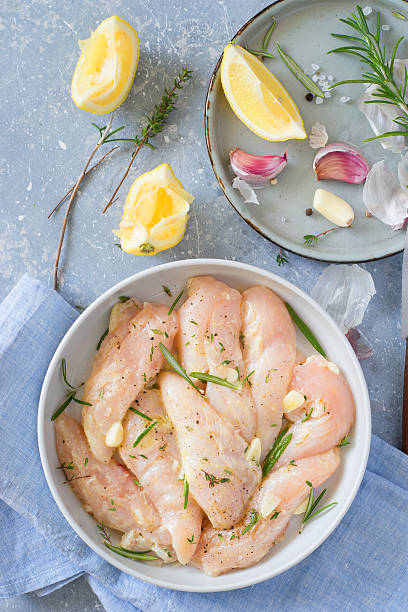 Raw chicken tenders marinated with garlic, lemon and herbs