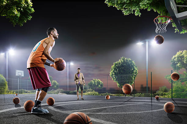 istock Basketball players working out on night court 619371034
