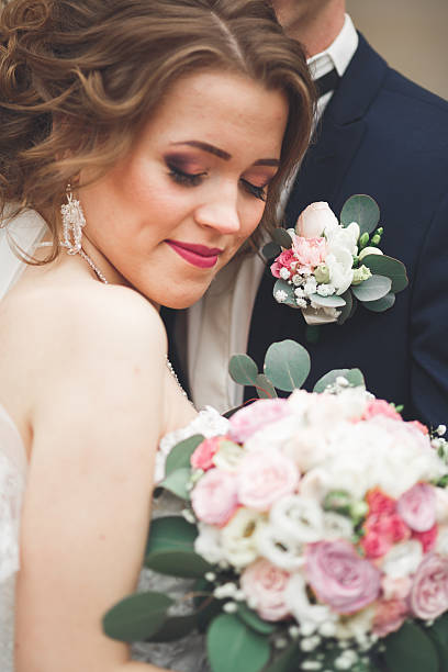 istock Just married wedding couple posing and bride holding in hands 619372114